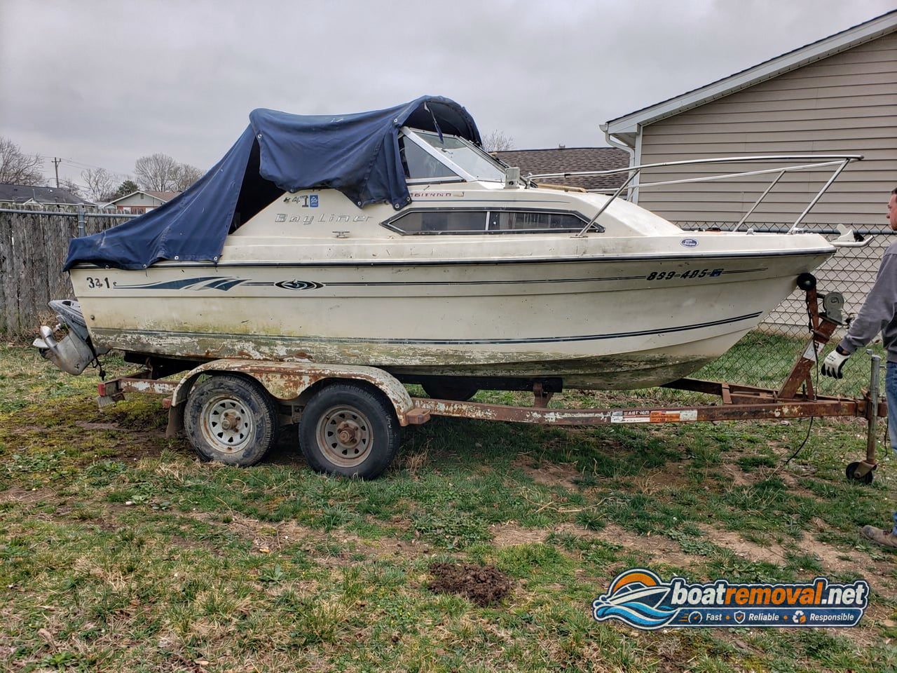 junk boat removal, 24 ft Bayliner cabin cruiser on a dead trailer