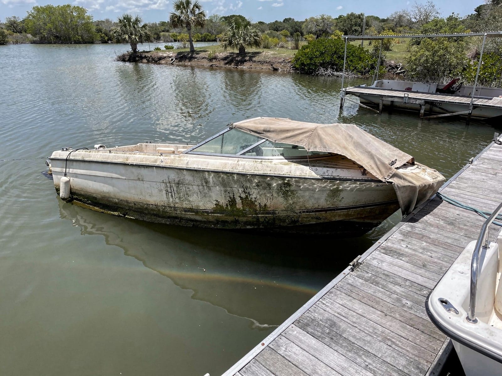 Sunken boat recovery in Altamonte Springs, FL: before Sunken 23 ft Chris-Craft Cavalier at a lake dock in Altamonte Springs, FL