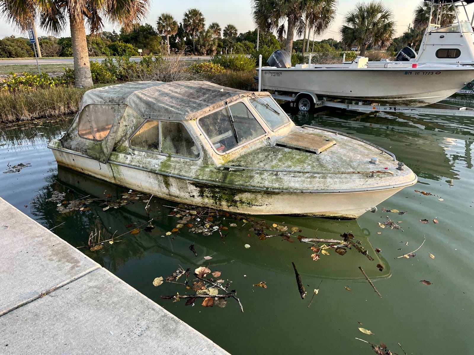 Sunken boat recovery in Azalea Park, FL: before Sunken 21 ft Thompson 21 by a boat ramp in Azalea Park, FL