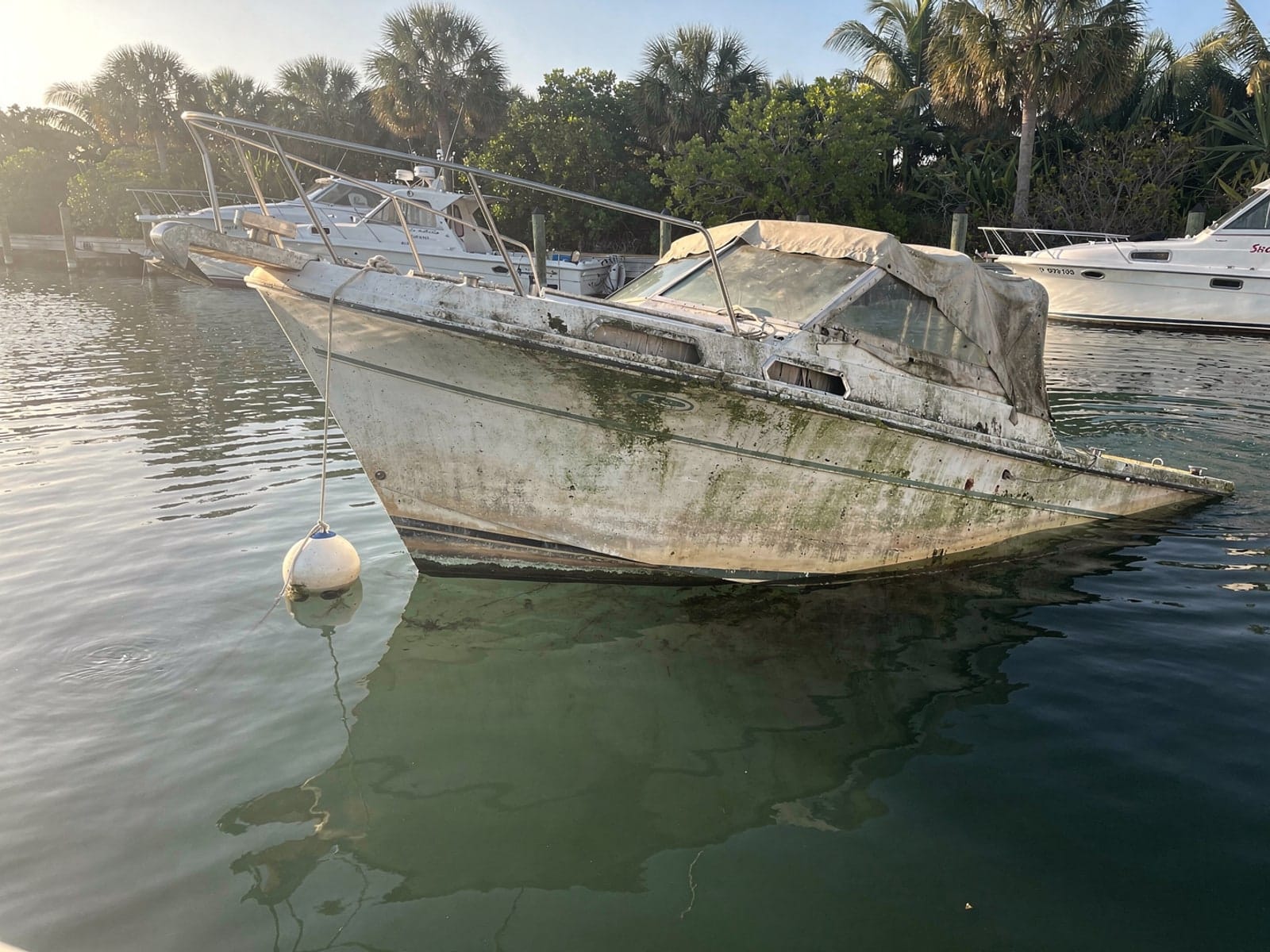 Sunken boat recovery in Belle Glade, FL: before Sunken 27 ft Chris-Craft Commander 27 at its mooring in Belle Glade, FL