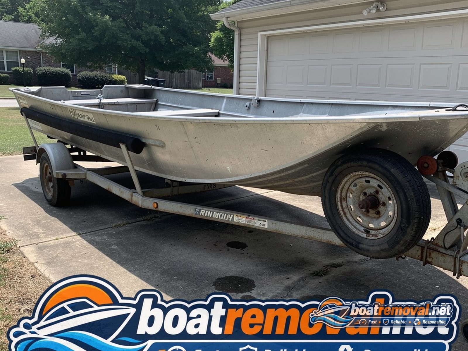 16-foot Lund aluminum fishing boat sitting on a flat-tired trailer beside a garage in Birmingham, Alabama