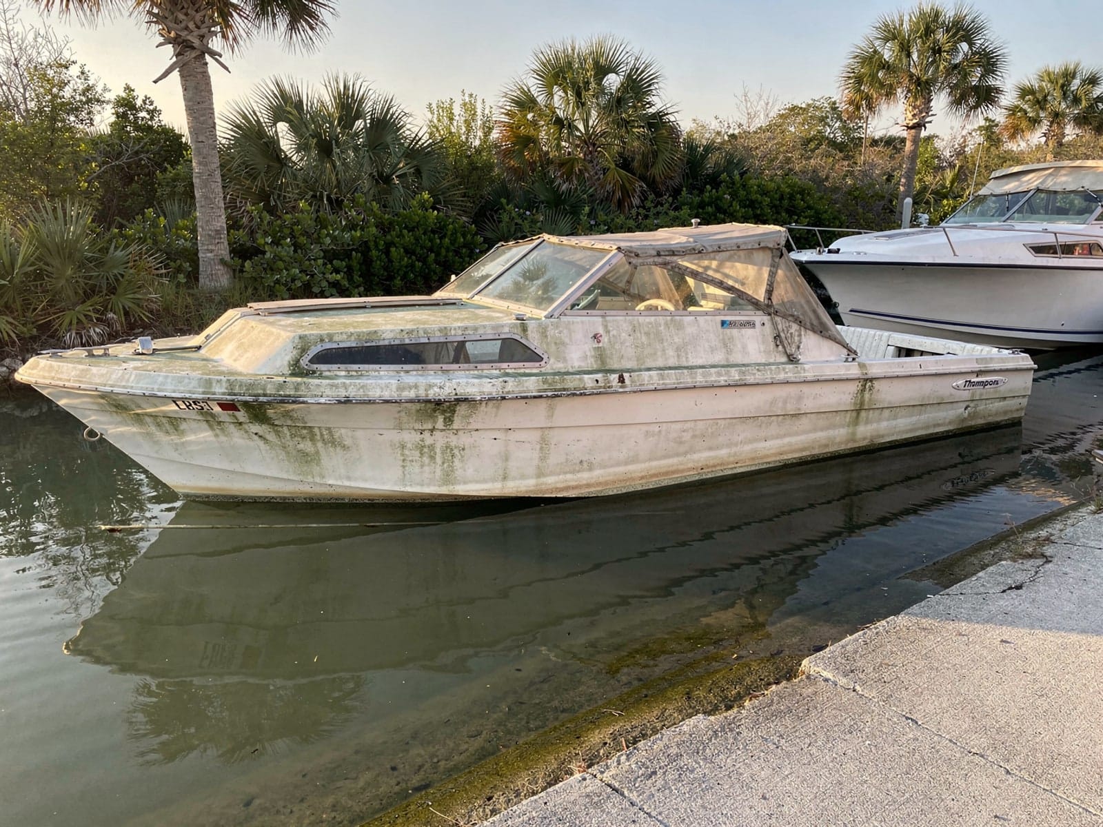 Sunken boat recovery in Bithlo, FL: before Sunken 21 ft Thompson 21 by a boat ramp in Bithlo, FL