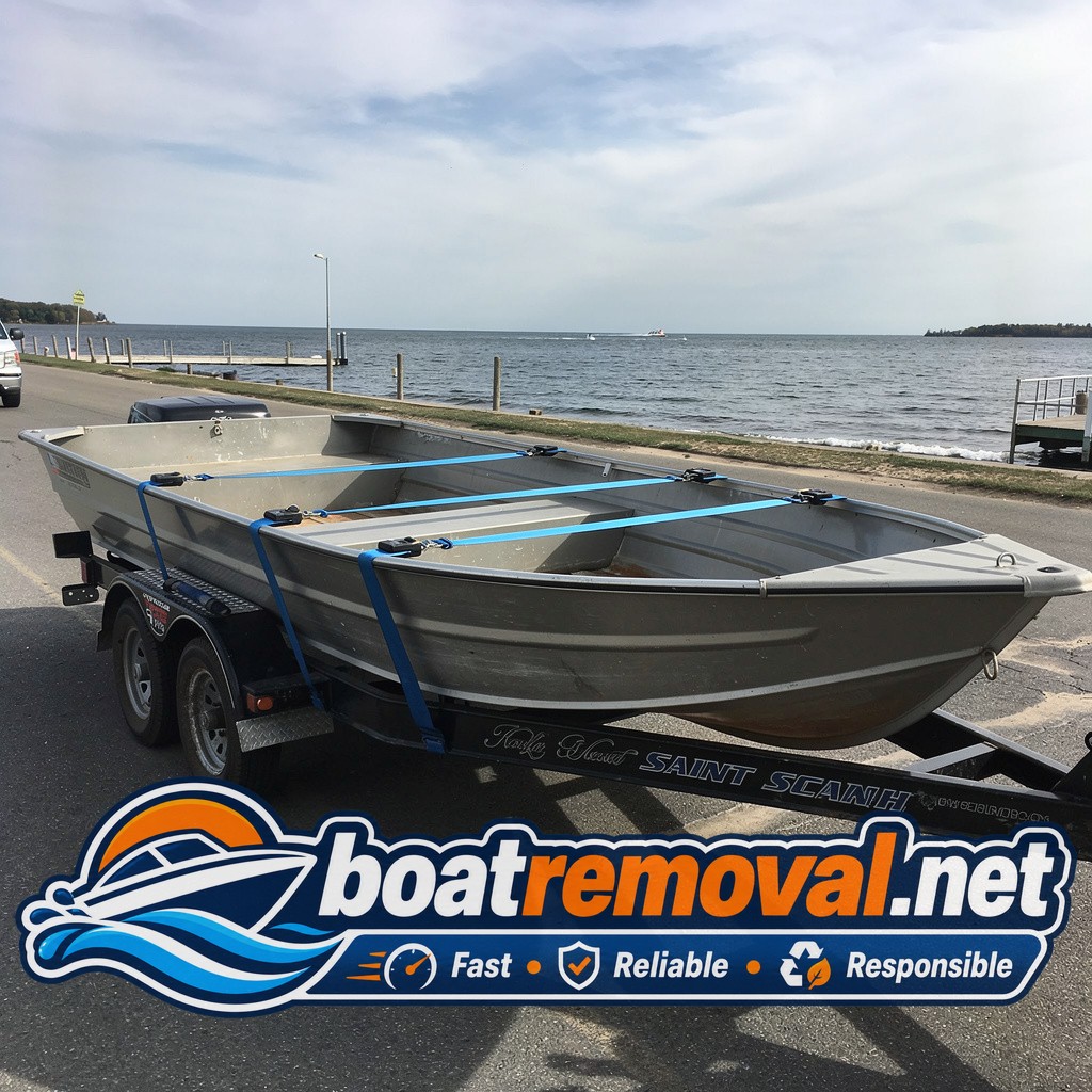 Same aluminum fishing boat loaded flat on the removal truck bed after leaving the ramp