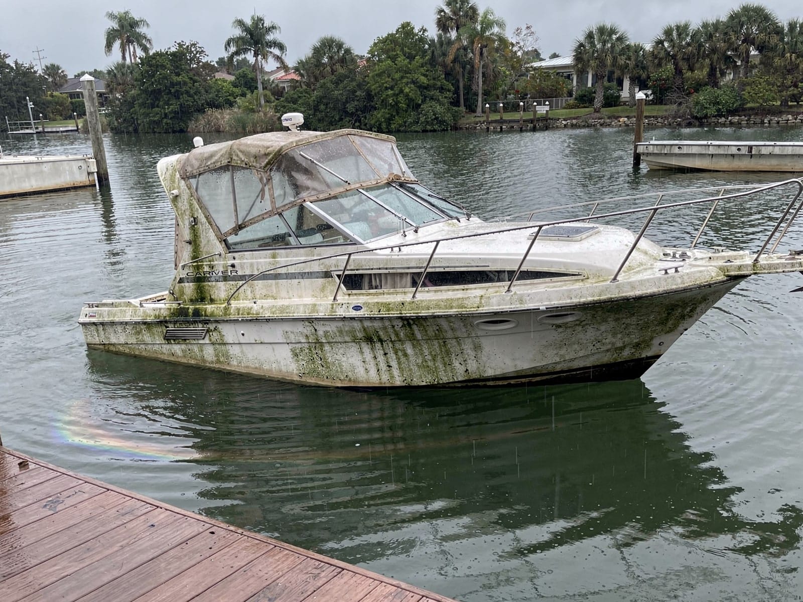 Sunken boat recovery in Marion Oaks, FL: before Sunken 28 ft Carver 28 at a lake dock in Marion Oaks, FL