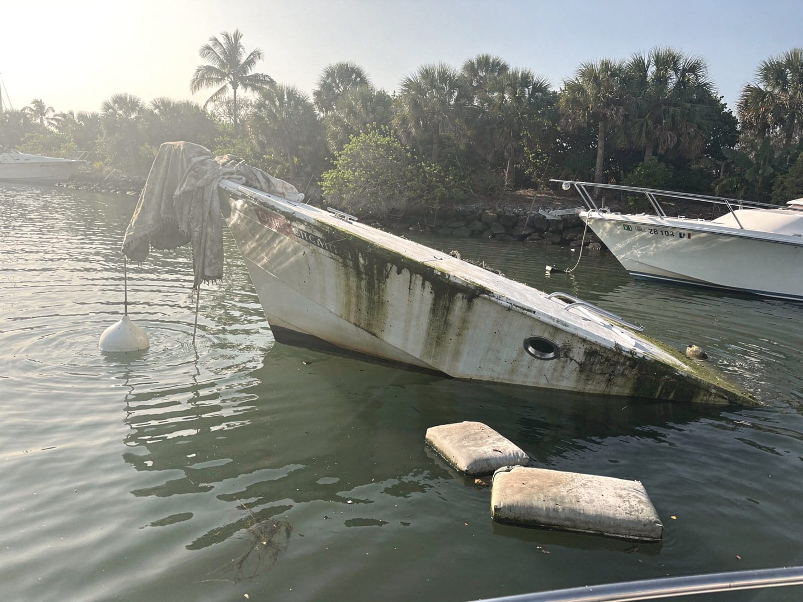 Sunken boat recovery in Vero Beach, FL: before Sunken 27 ft Chris-Craft Commander 27 at its mooring in Vero Beach, FL