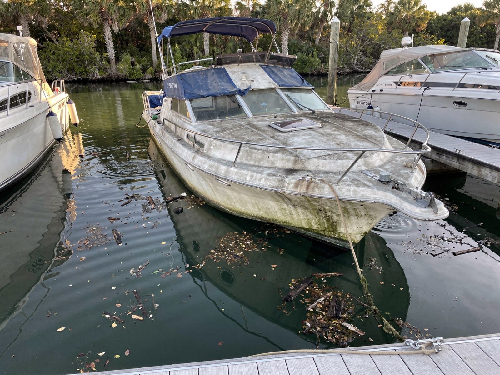 Sunken boat recovery in Jacksonville, FL: before Sunken 34 ft Silverton 34 in a marina slip in Jacksonville, FL