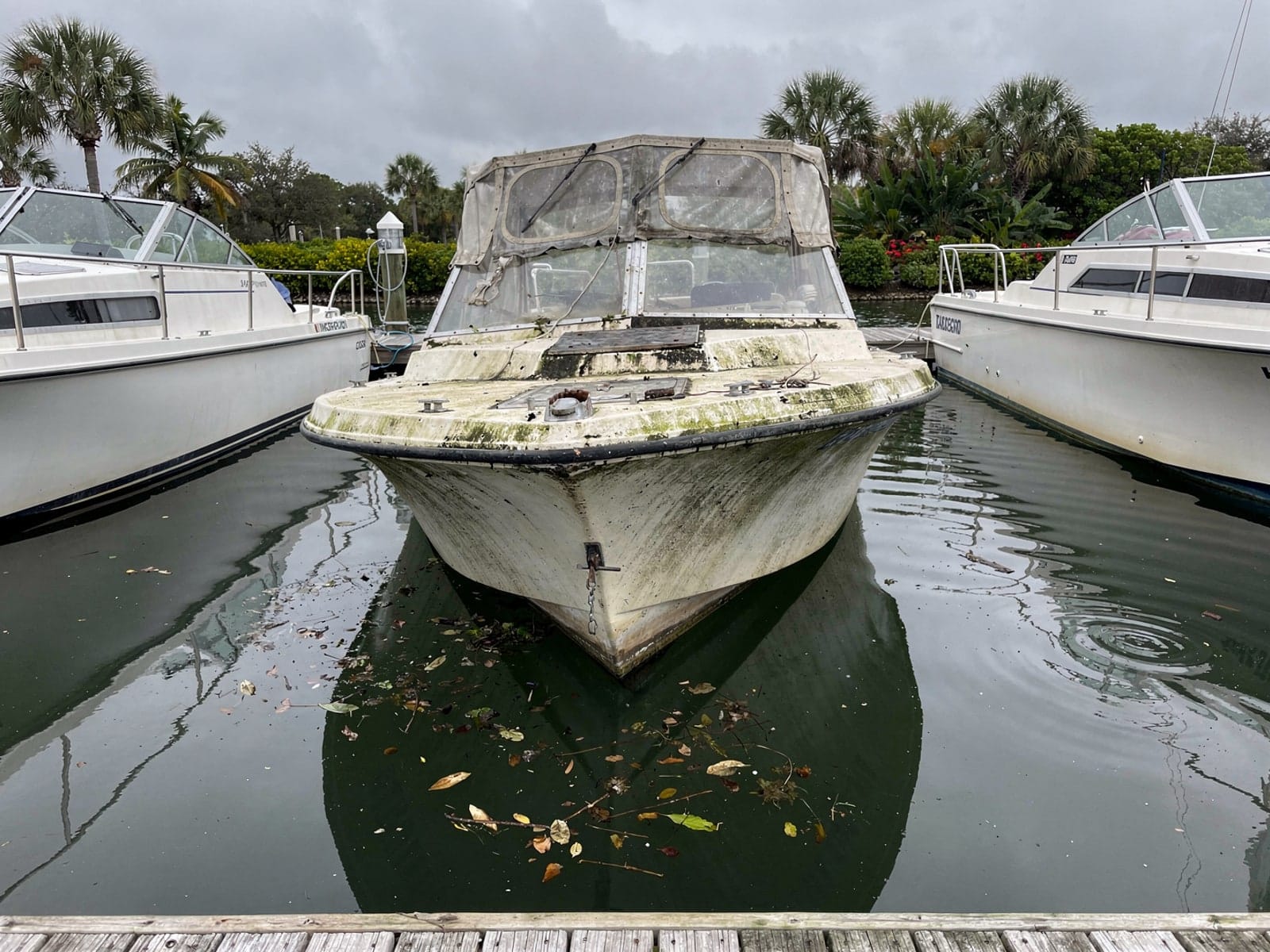 Sunken boat recovery in Melbourne, FL: before Sunken 26 ft MacGregor 26 in a marina slip in Melbourne, FL