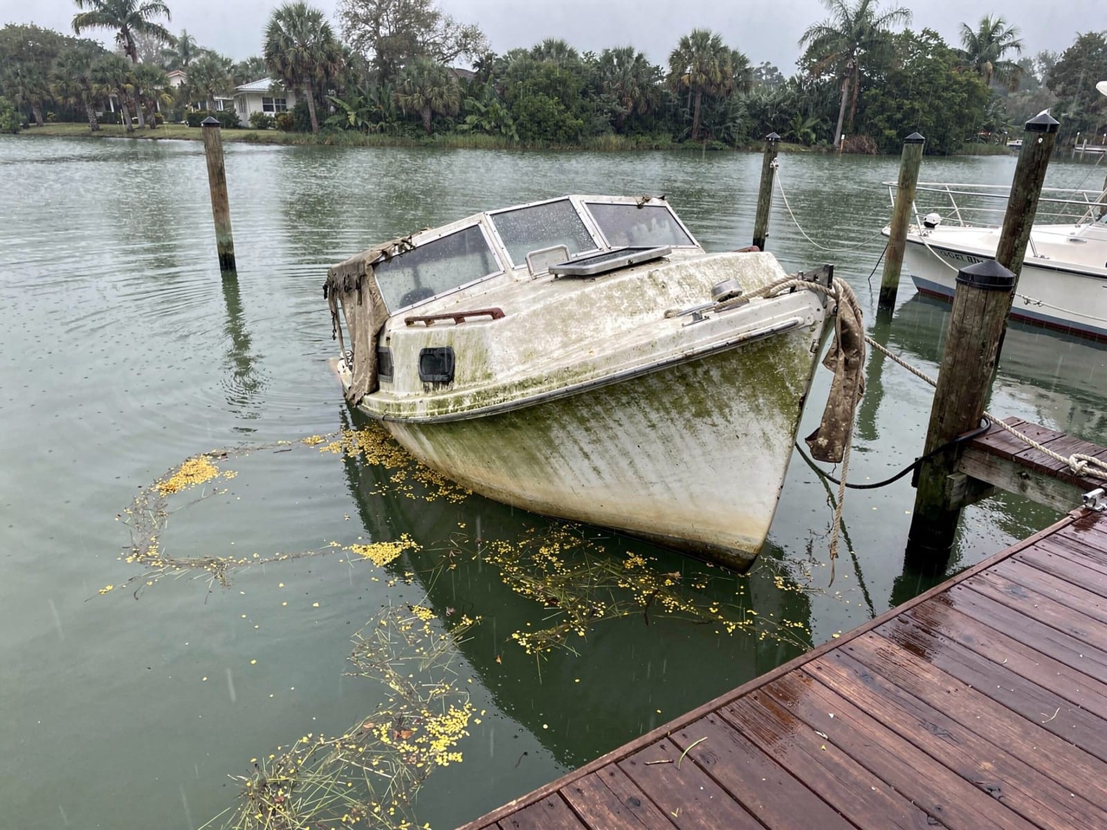 Sunken 26 ft Pearson 26 at a lake dock in St Cloud, FL
