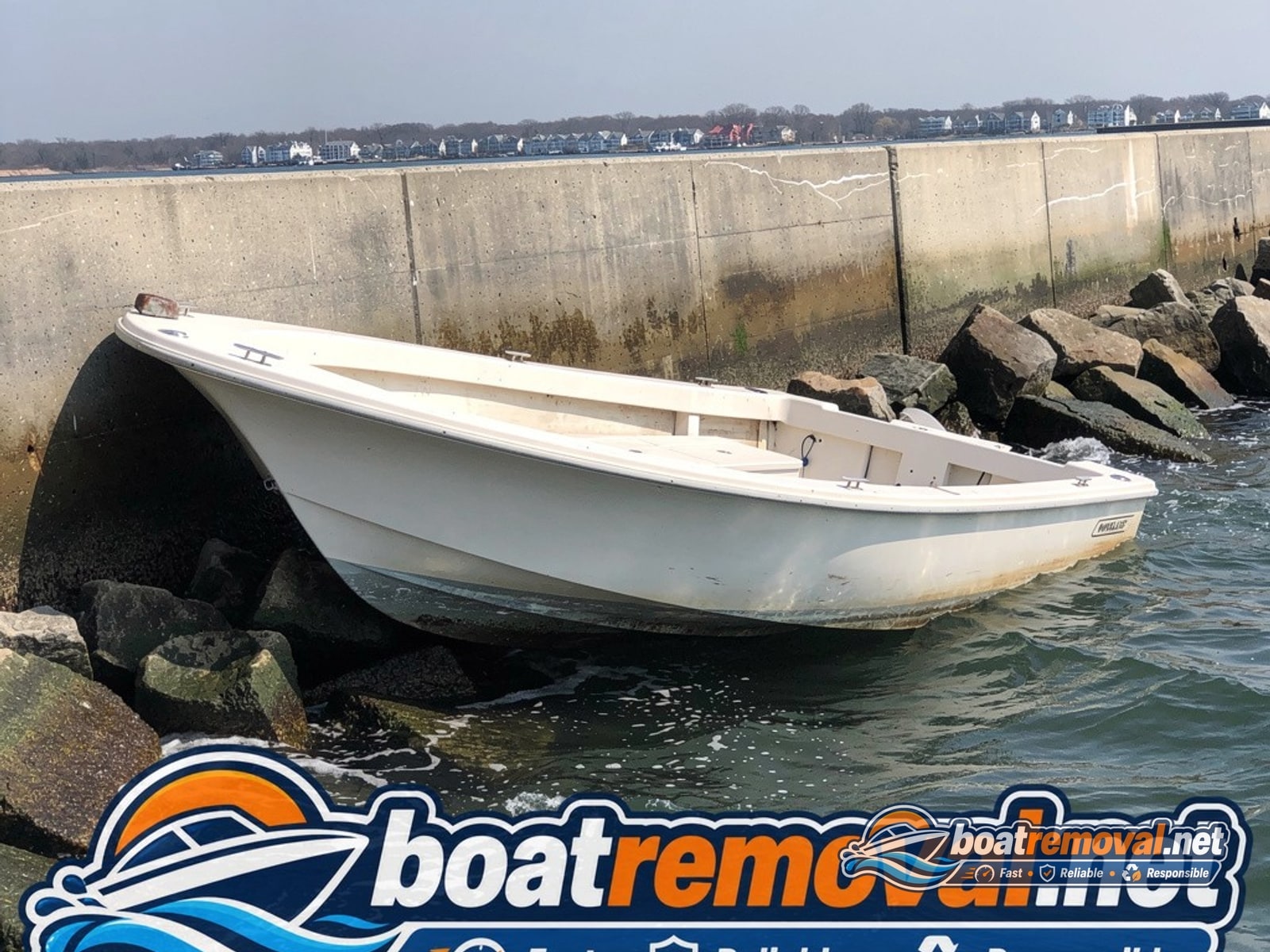 24-foot Boston Whaler wedged against rocks near a seawall in Groton, Connecticut