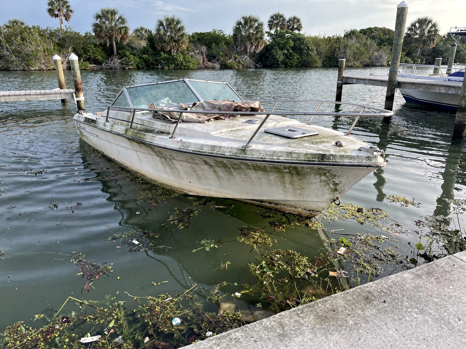 Sunken 22 ft Larson 220 by a boat ramp in West Little River, FL