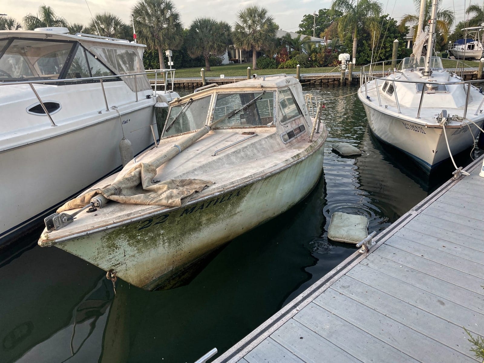 Sunken boat recovery in Boynton Beach, FL: before Sunken 22 ft Catalina 22 in a marina slip in Boynton Beach, FL