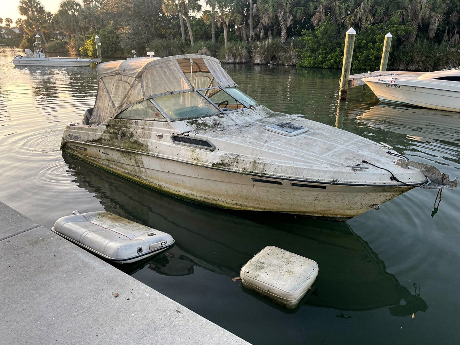 Sunken boat recovery in Buenaventura Lakes, FL: before Sunken 24 ft Bayliner 2455 Ciera by a boat ramp in Buenaventura Lakes, FL