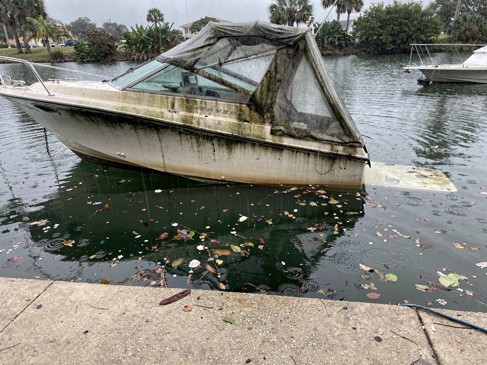 Sunken boat recovery in Four Corners, FL: before Sunken 28 ft Carver 28 by a boat ramp in Four Corners, FL