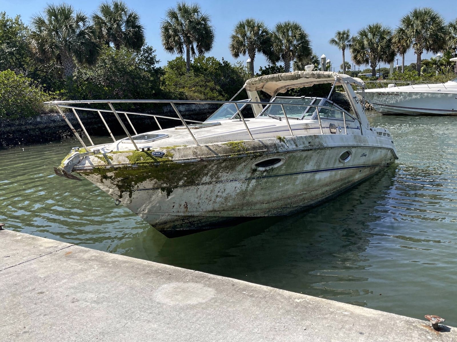 Sunken boat recovery in New Smyrna Beach, FL: before Sunken 26 ft Sea Ray 268 Sundancer by a boat ramp in New Smyrna Beach, FL
