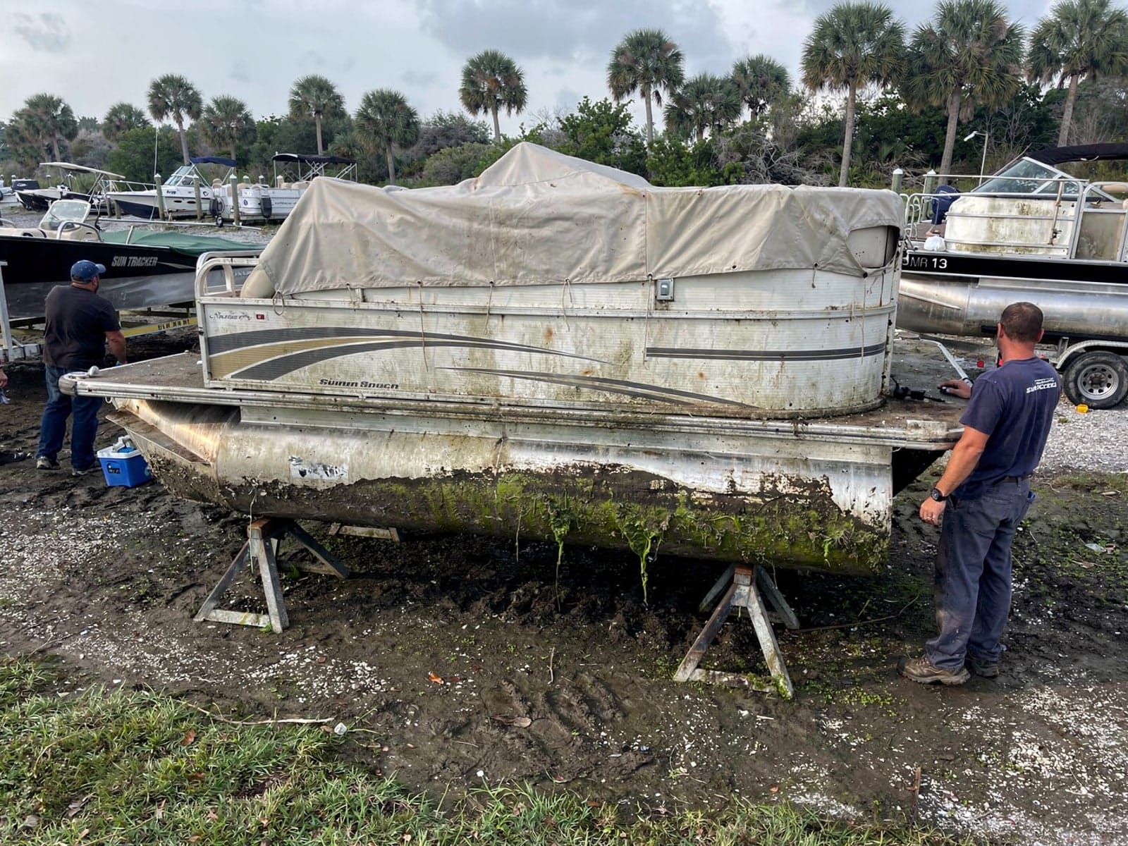 22 ft Sun Tracker Party Barge 22 from Clearwater, FL on stands at a repair yard after the recovery