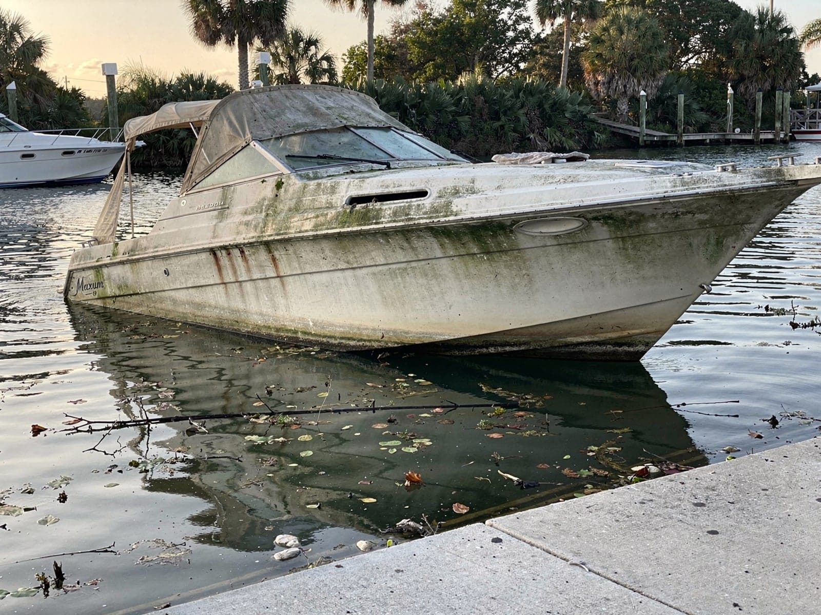 Sunken boat recovery in Coconut Creek, FL: before Sunken 24 ft Maxum 2400 SCR by a boat ramp in Coconut Creek, FL