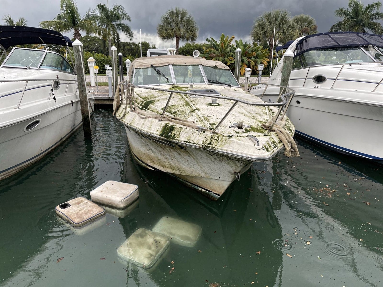 Sunken boat recovery in Crestview, FL: before Sunken 23 ft Rinker 232 in a marina slip in Crestview, FL