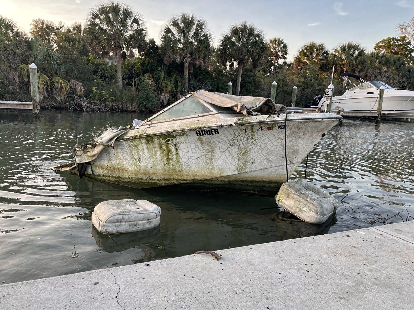 Sunken boat recovery in Dania Beach, FL: before Sunken 23 ft Rinker 232 by a boat ramp in Dania Beach, FL