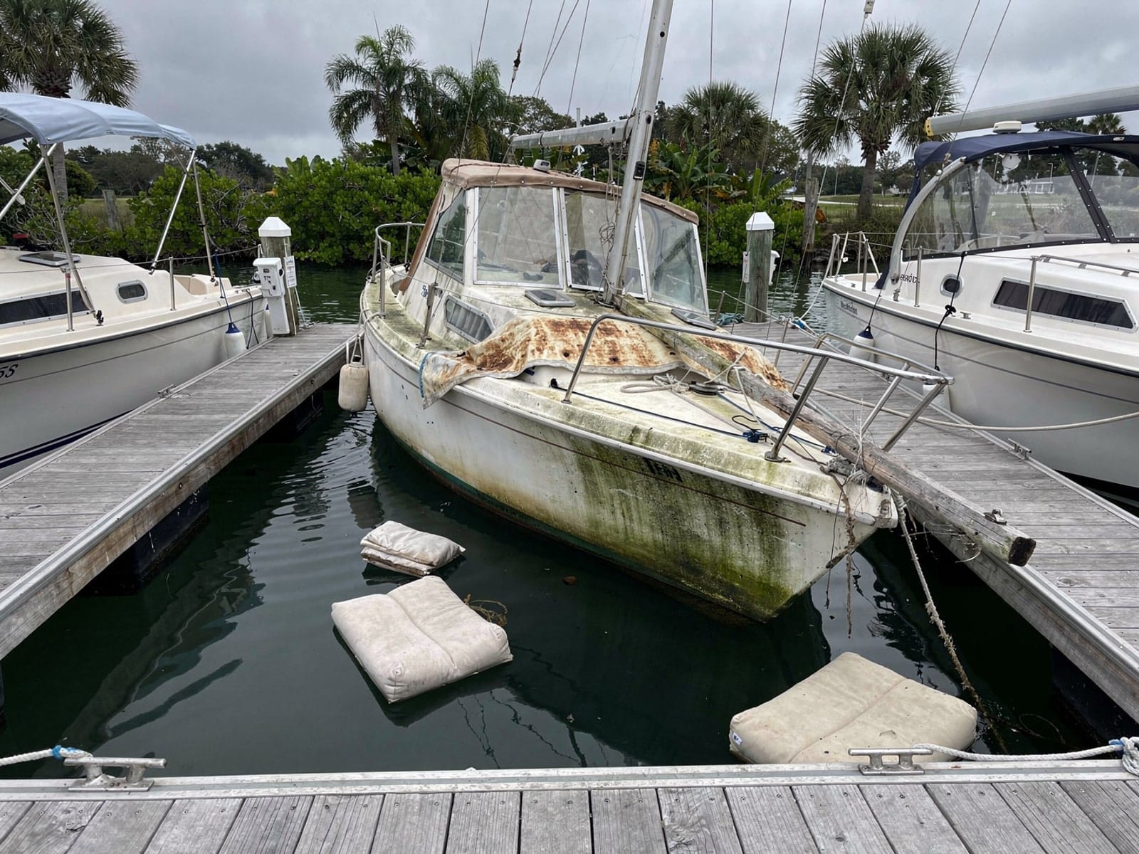Sunken boat recovery in Deerfield Beach, FL: before Sunken 22 ft Catalina 22 in a marina slip in Deerfield Beach, FL