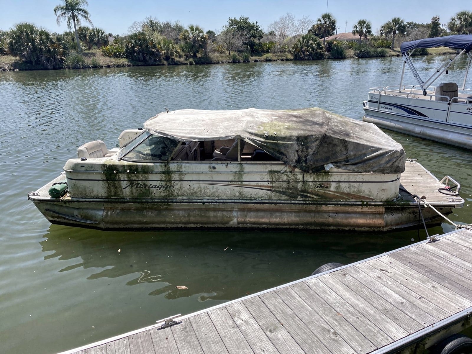 Sunken boat recovery in Doctor Phillips, FL: before Sunken 20 ft Sylvan Mirage 20 at a lake dock in Doctor Phillips, FL