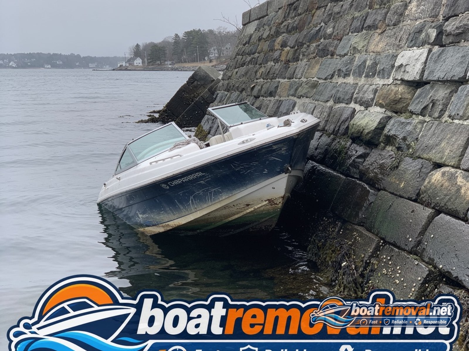 24-foot Chaparral bowrider listing against a tidal seawall in Dover, New Hampshire after storm damage