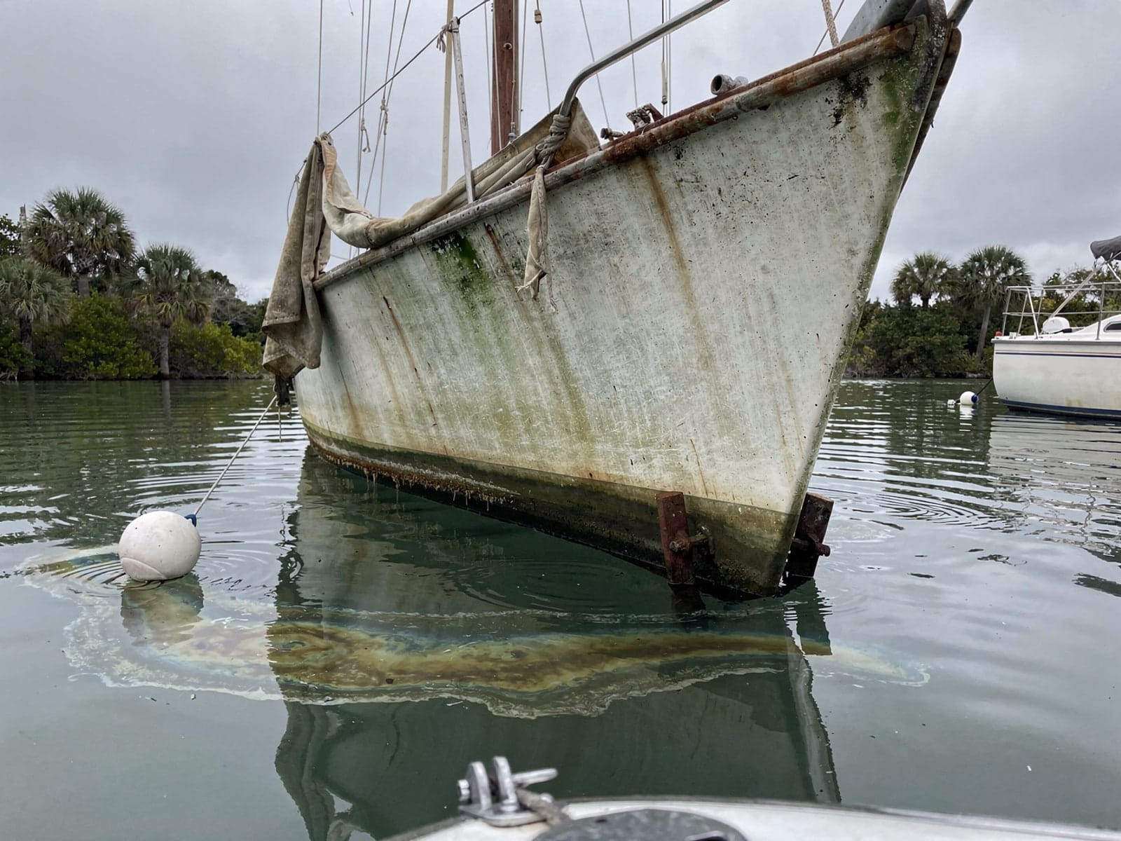 Sunken boat recovery in Estero, FL: before Sunken 25 ft O'Day 25 at its mooring in Estero, FL