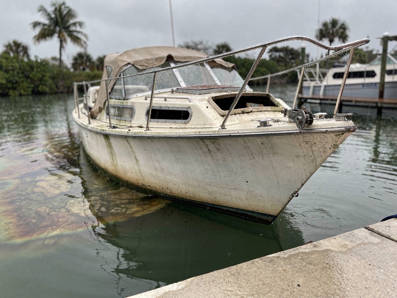 Sunken boat recovery in Golden Gate, FL: before Sunken 27 ft Ericson 27 by a boat ramp in Golden Gate, FL