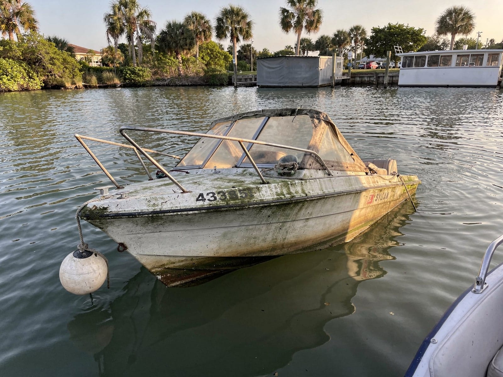 Sunken boat recovery in Goulds, FL: before Sunken 20 ft Sylvan Mirage 20 at its mooring in Goulds, FL