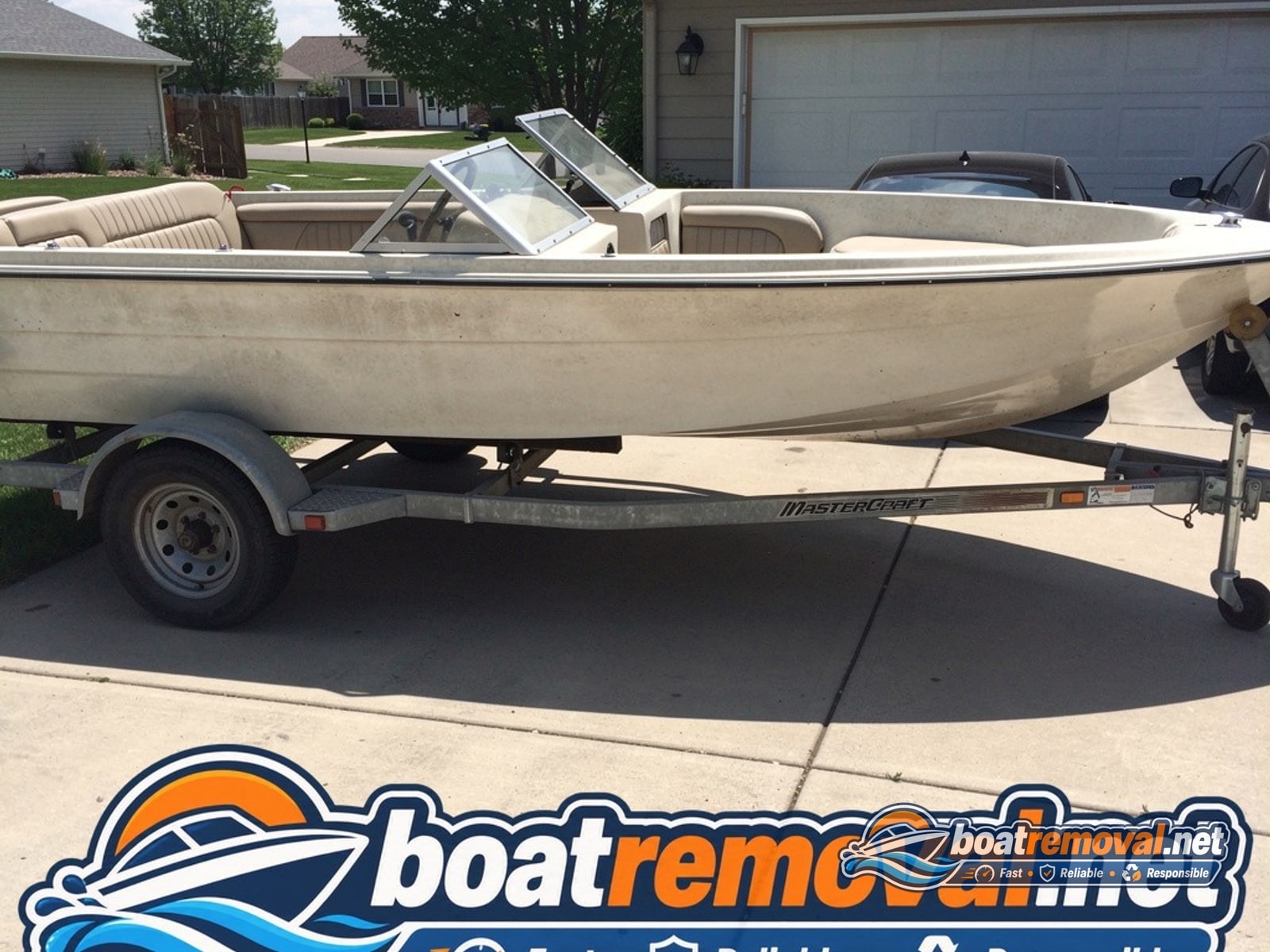 17-foot MasterCraft ski boat on a trailer in a Great Falls, Montana driveway before removal