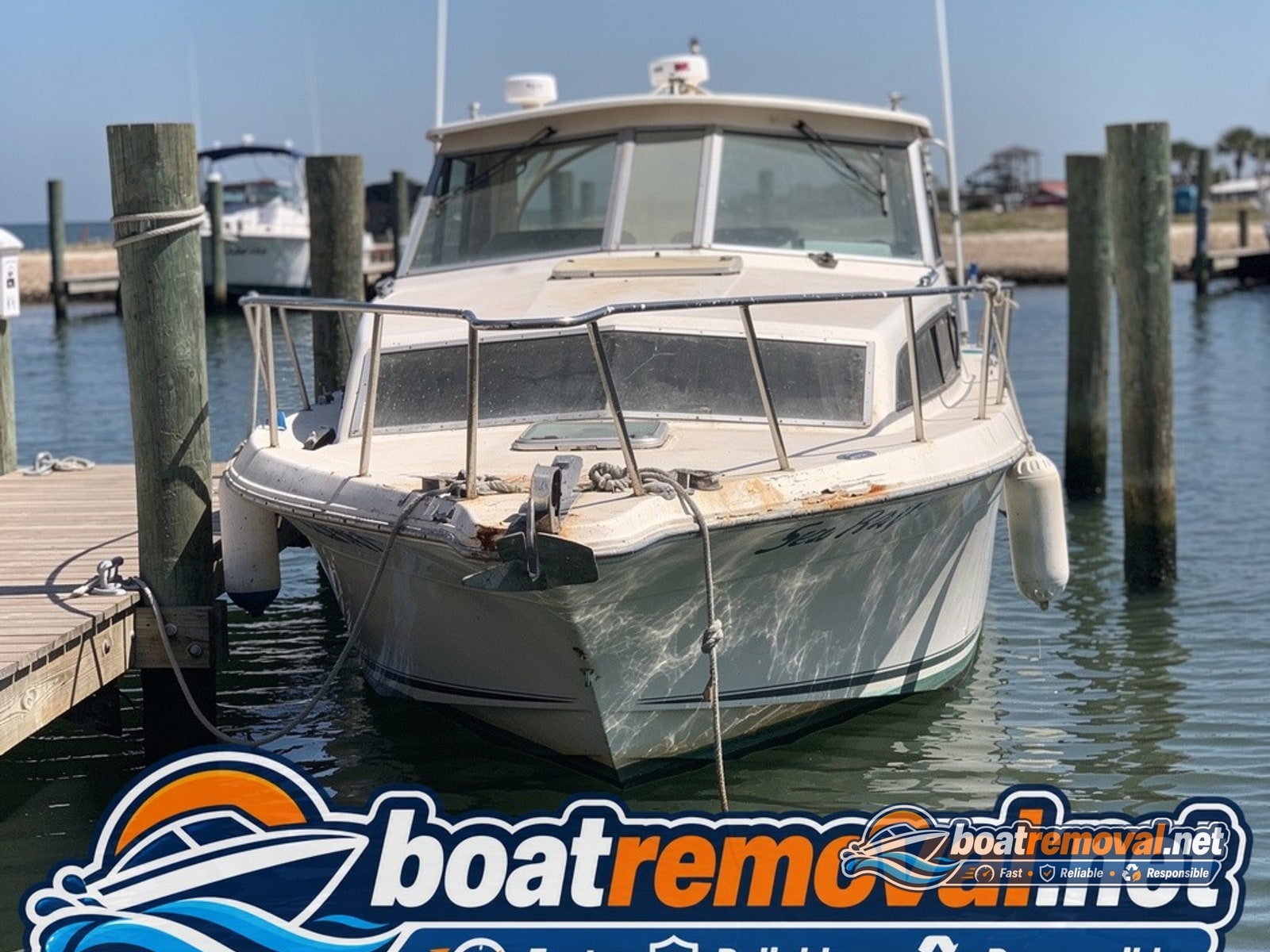 Weathered 26-foot Sea Ray cabin cruiser tied up in a marina slip in Gulf Shores, Alabama