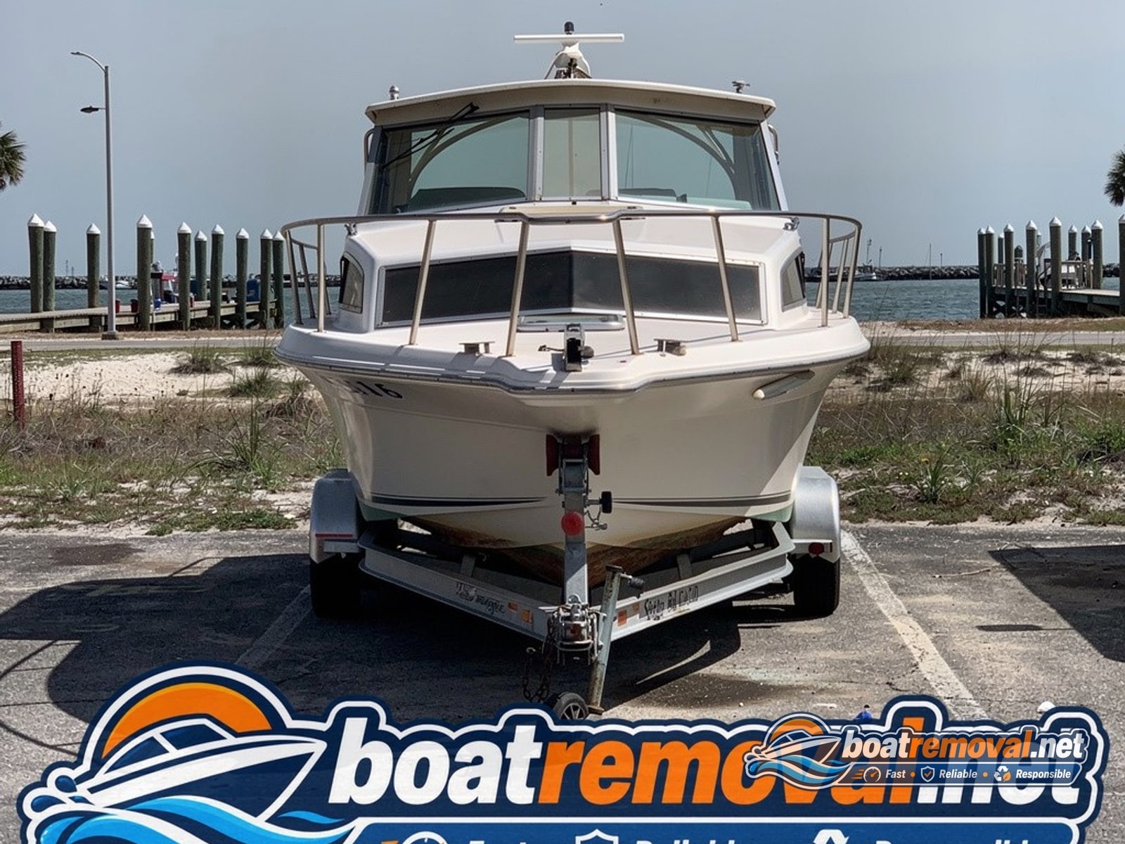 Gulf Shores, AL: 26-foot Sea Ray cabin cruiser loaded for removal Sea Ray cabin cruiser loaded onto a trailer after removal from a Gulf Shores marina