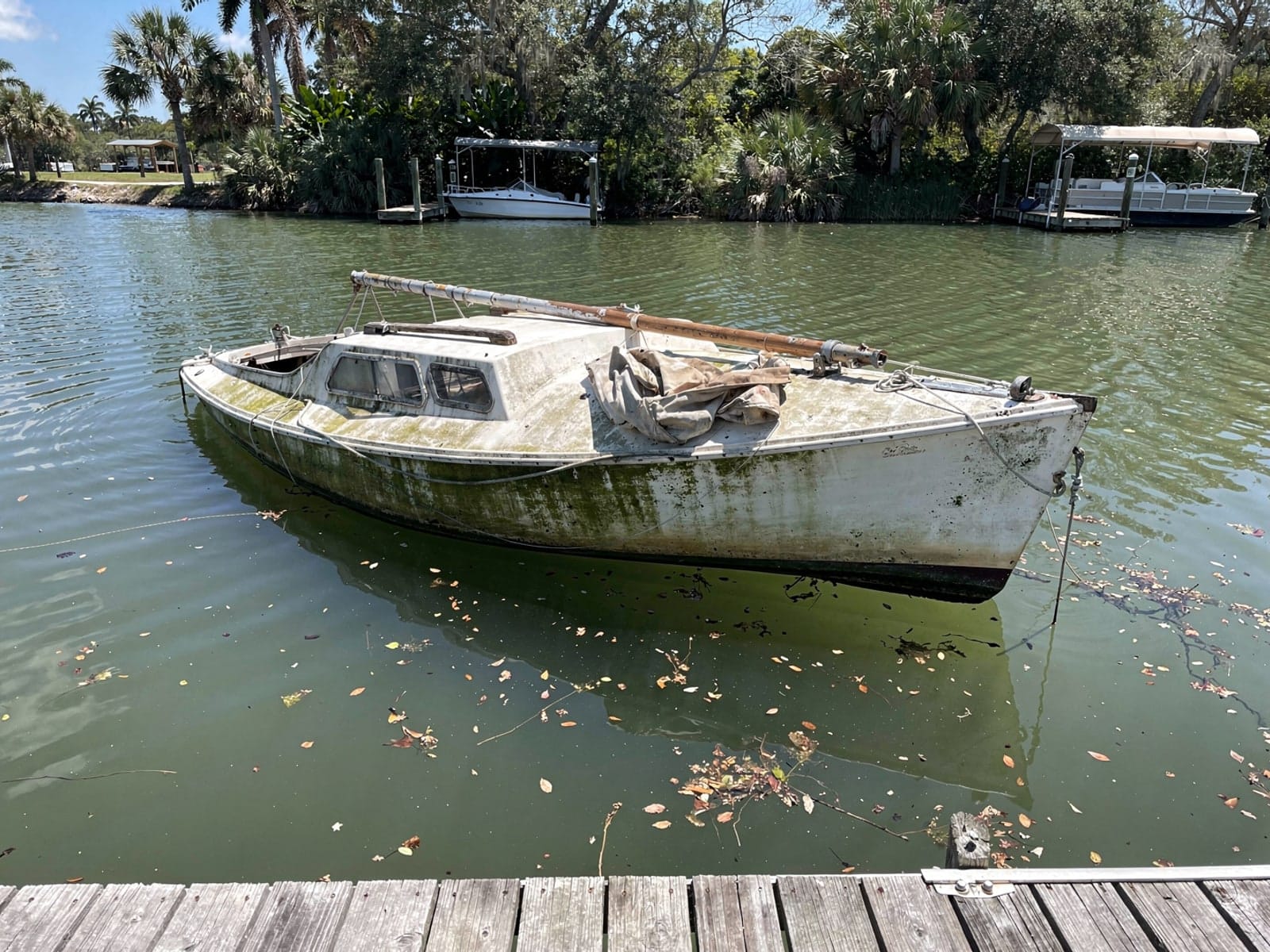 Sunken boat recovery in Bayonet Point, FL: before Sunken 22 ft Catalina 22 at a lake dock in Bayonet Point, FL