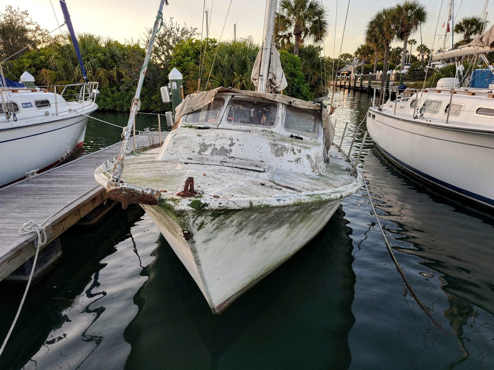Sunken boat recovery in Deltona, FL: before Sunken 27 ft Cal 27 in a marina slip in Deltona, FL