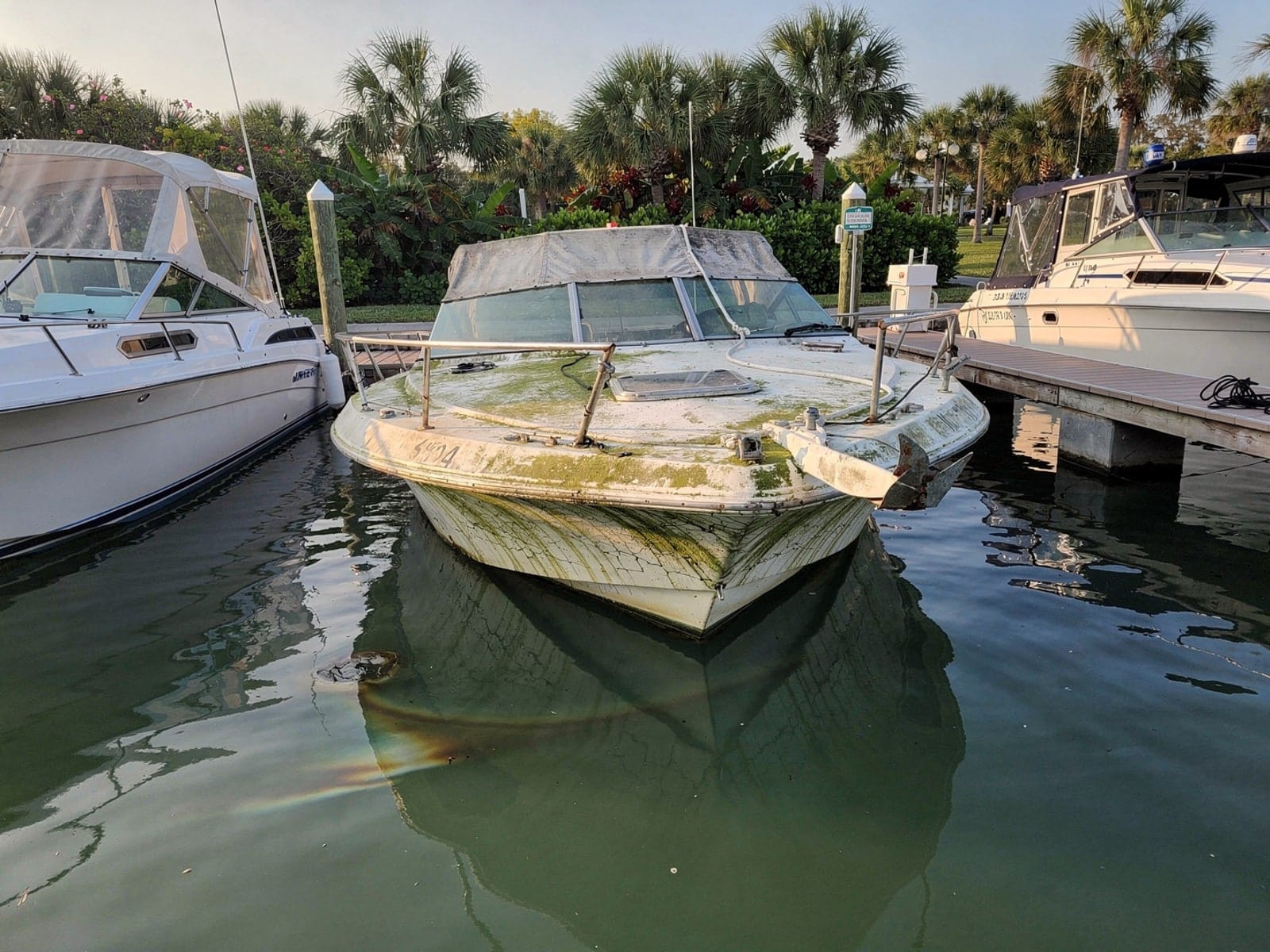 Sunken boat recovery in Navarre, FL: before Sunken 23 ft Rinker 232 in a marina slip in Navarre, FL