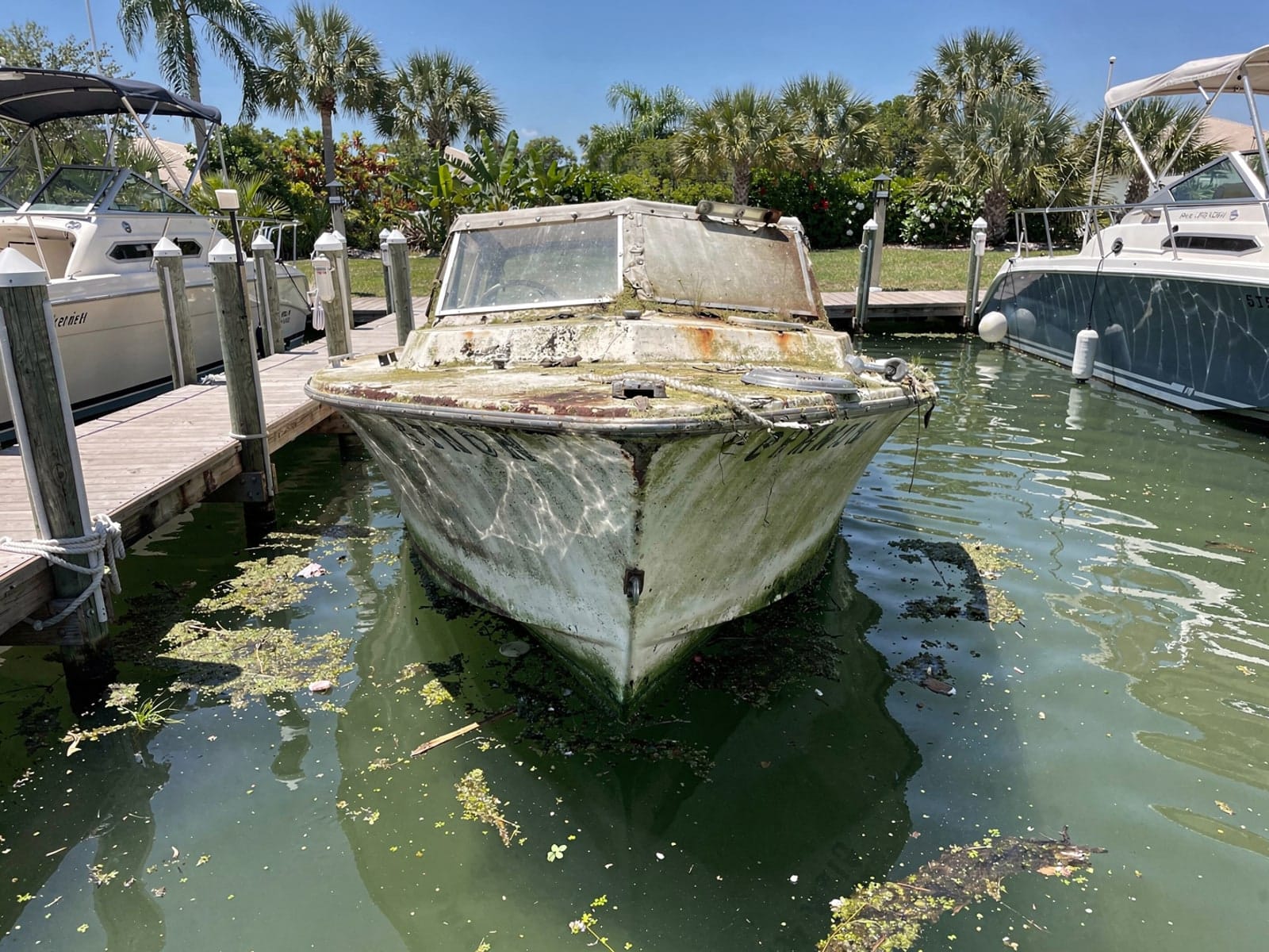 Sunken boat recovery in Pompano Beach, FL: before Sunken 21 ft Thompson 21 in a marina slip in Pompano Beach, FL