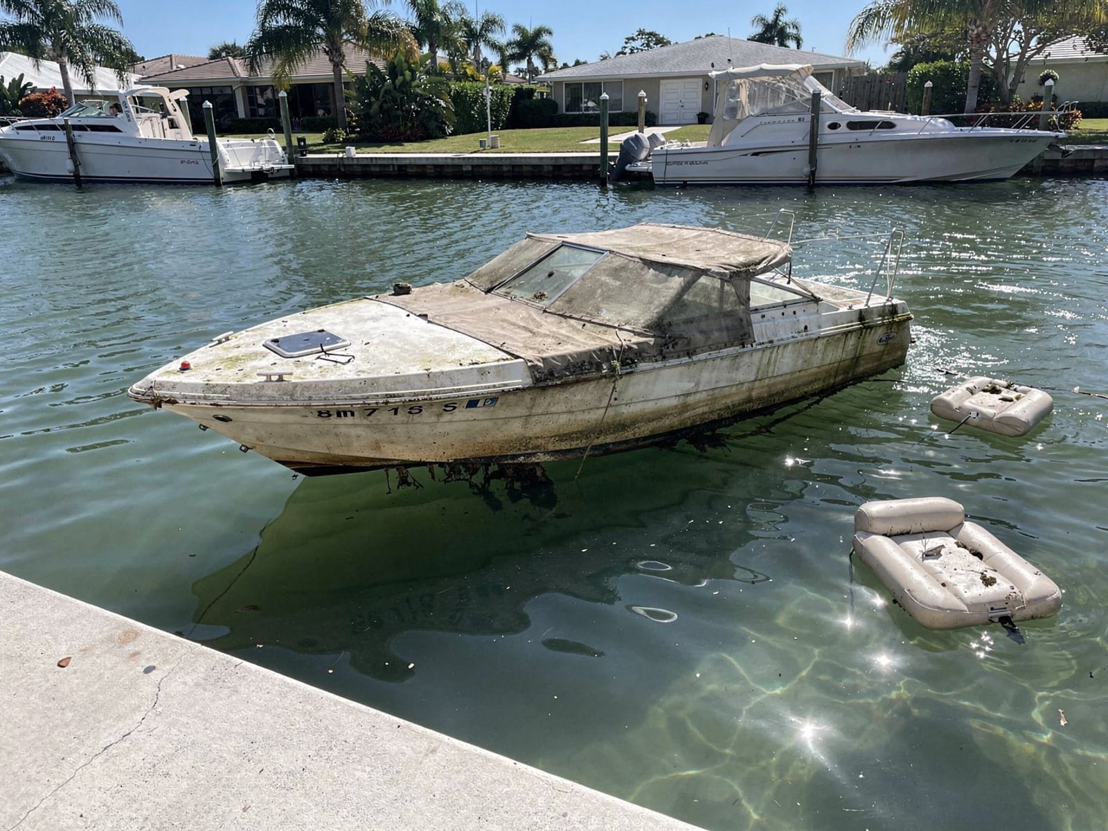 Sunken boat recovery in Rockledge, FL: before Sunken 24 ft Formula 242 in a canal by the seawall in Rockledge, FL