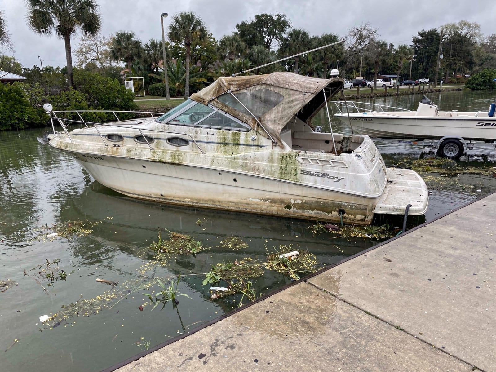 Sunken boat recovery in Silver Springs Shores, FL: before Sunken 26 ft Sea Ray 268 Sundancer by a boat ramp in Silver Springs Shores, FL
