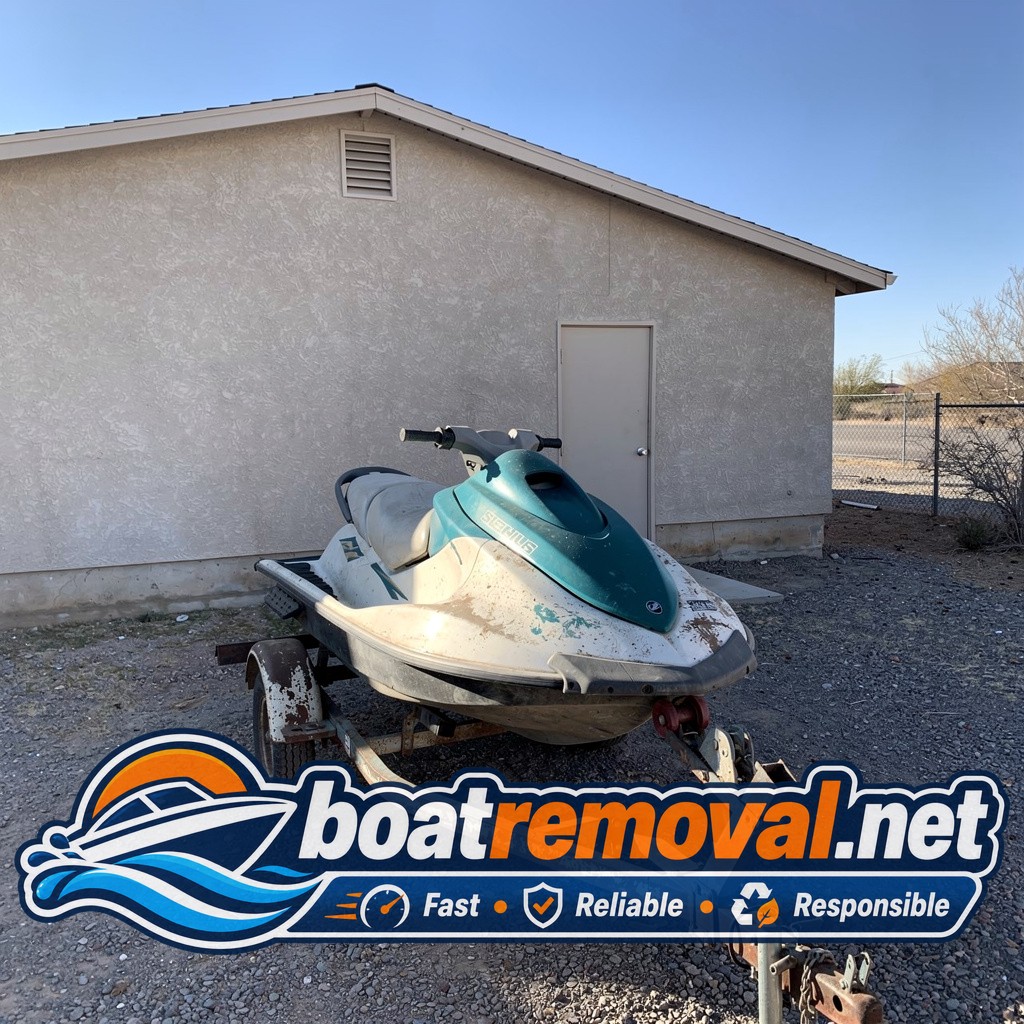 Two-seat jet ski on a rusted trailer behind a garage in Henderson, Nevada before pickup