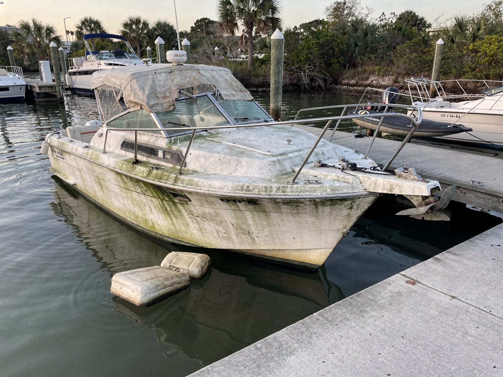 Sunken boat recovery in Hialeah Gardens, FL: before Sunken 27 ft Chris-Craft Commander 27 by a boat ramp in Hialeah Gardens, FL