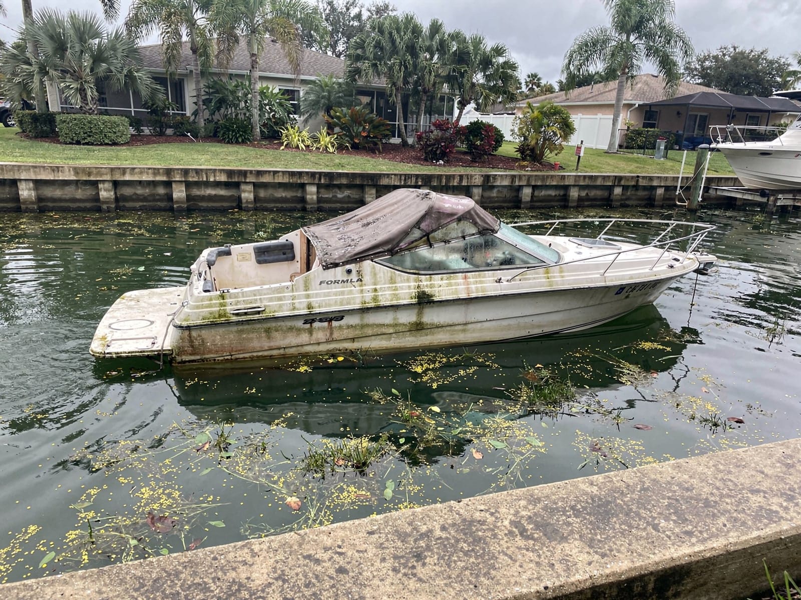 Sunken boat recovery in Hollywood, FL: before Sunken 24 ft Formula 242 in a canal by the seawall in Hollywood, FL