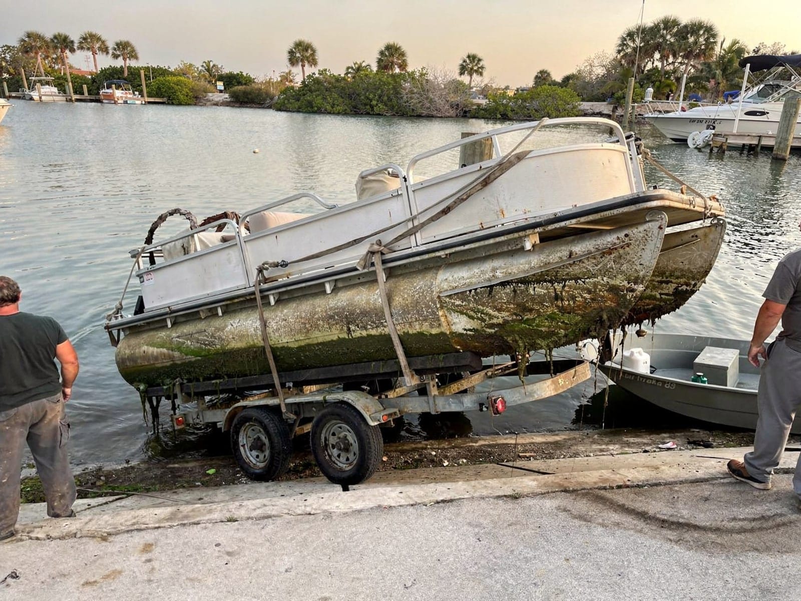 Sunken boat recovery in Jupiter Farms, FL: pulled out at the ramp 22 ft Sun Tracker Party Barge 22 pulled out on a trailer at a Jupiter Farms, FL boat ramp