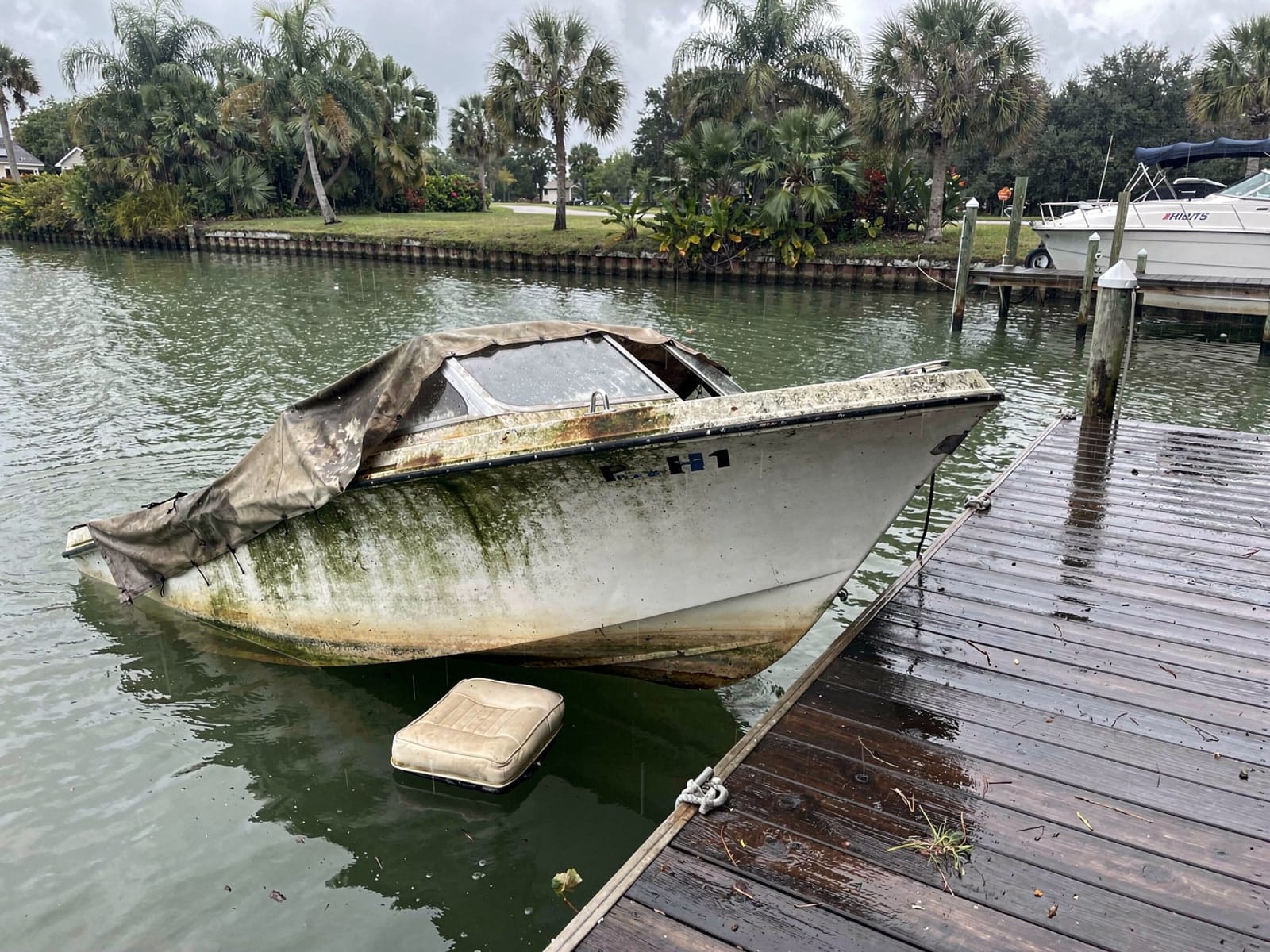 Sunken boat recovery in Keystone, FL: before Sunken 21 ft Thompson 21 at a lake dock in Keystone, FL