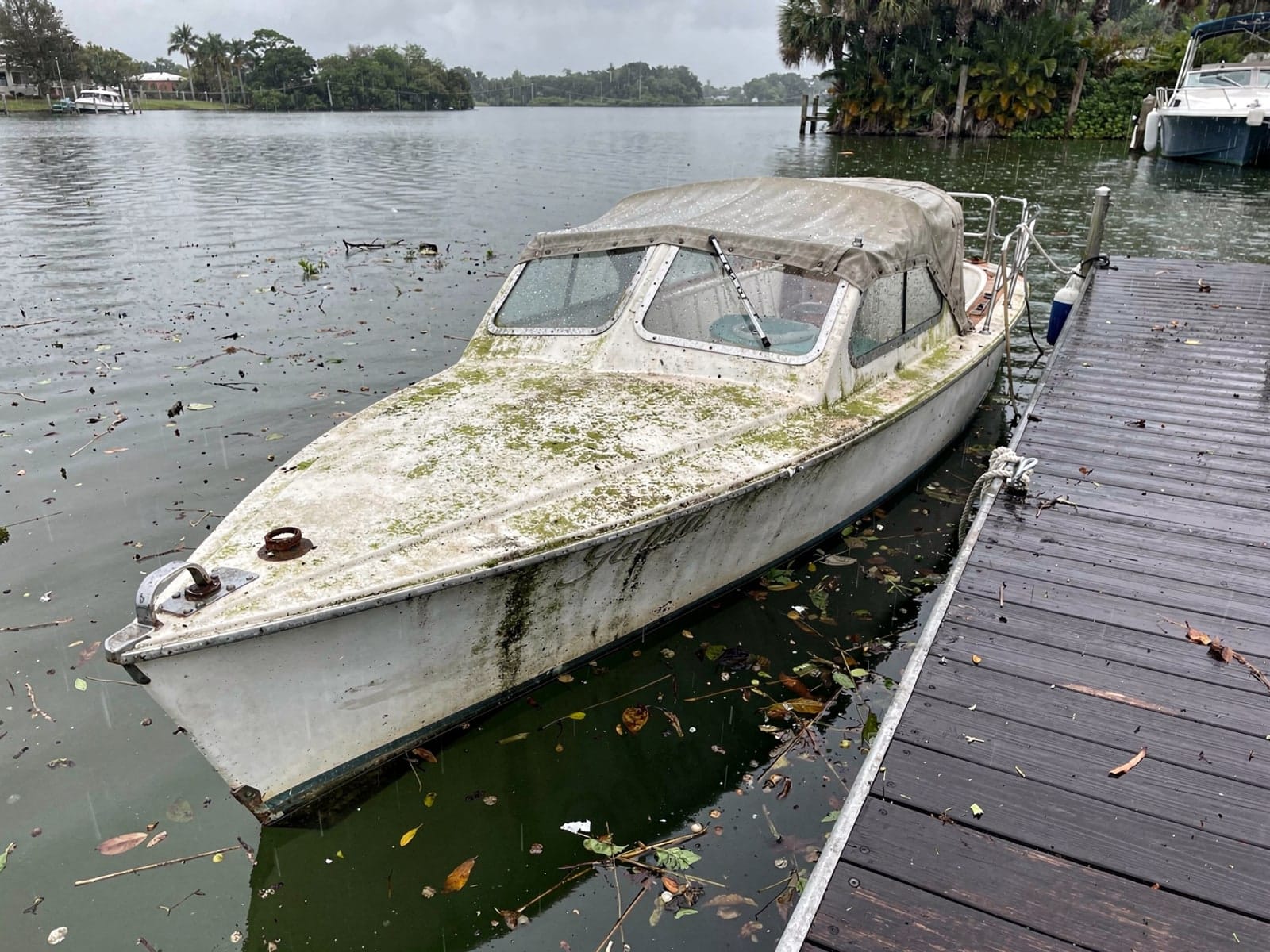 Sunken boat recovery in Lake Butler, FL: before Sunken 27 ft Cal 27 at a lake dock in Lake Butler, FL