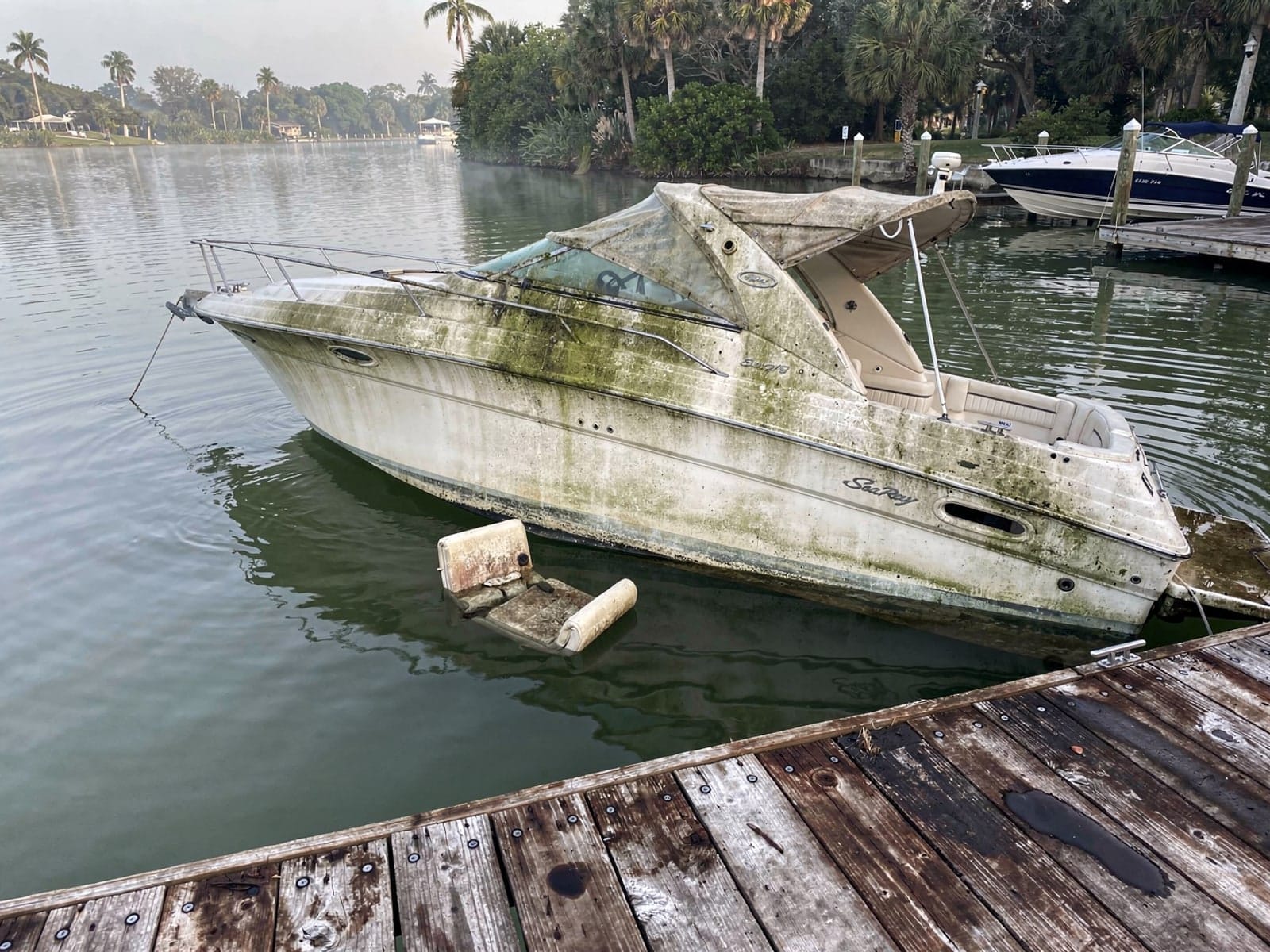 Sunken boat recovery in Lake Mary, FL: before Sunken 26 ft Sea Ray 268 Sundancer at a lake dock in Lake Mary, FL