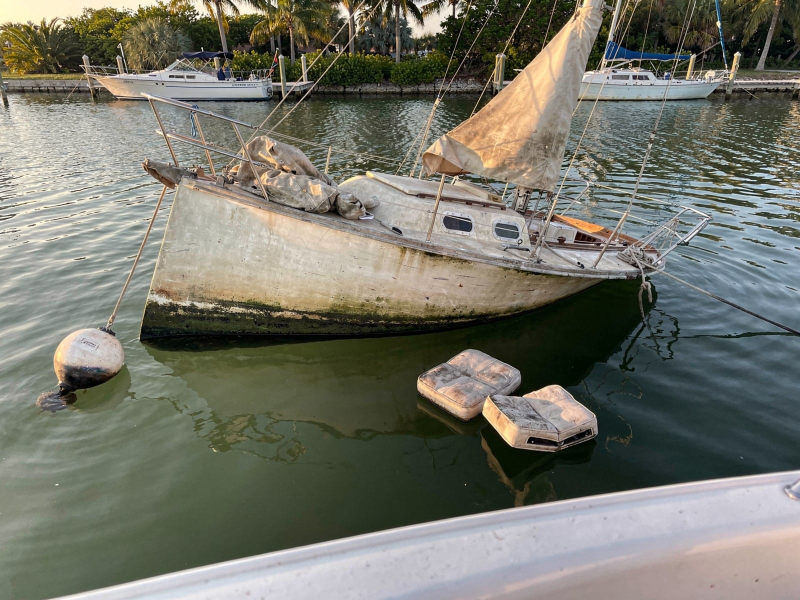 Sunken boat recovery in Lakeside, FL: before Sunken 27 ft Catalina 27 at its mooring in Lakeside, FL