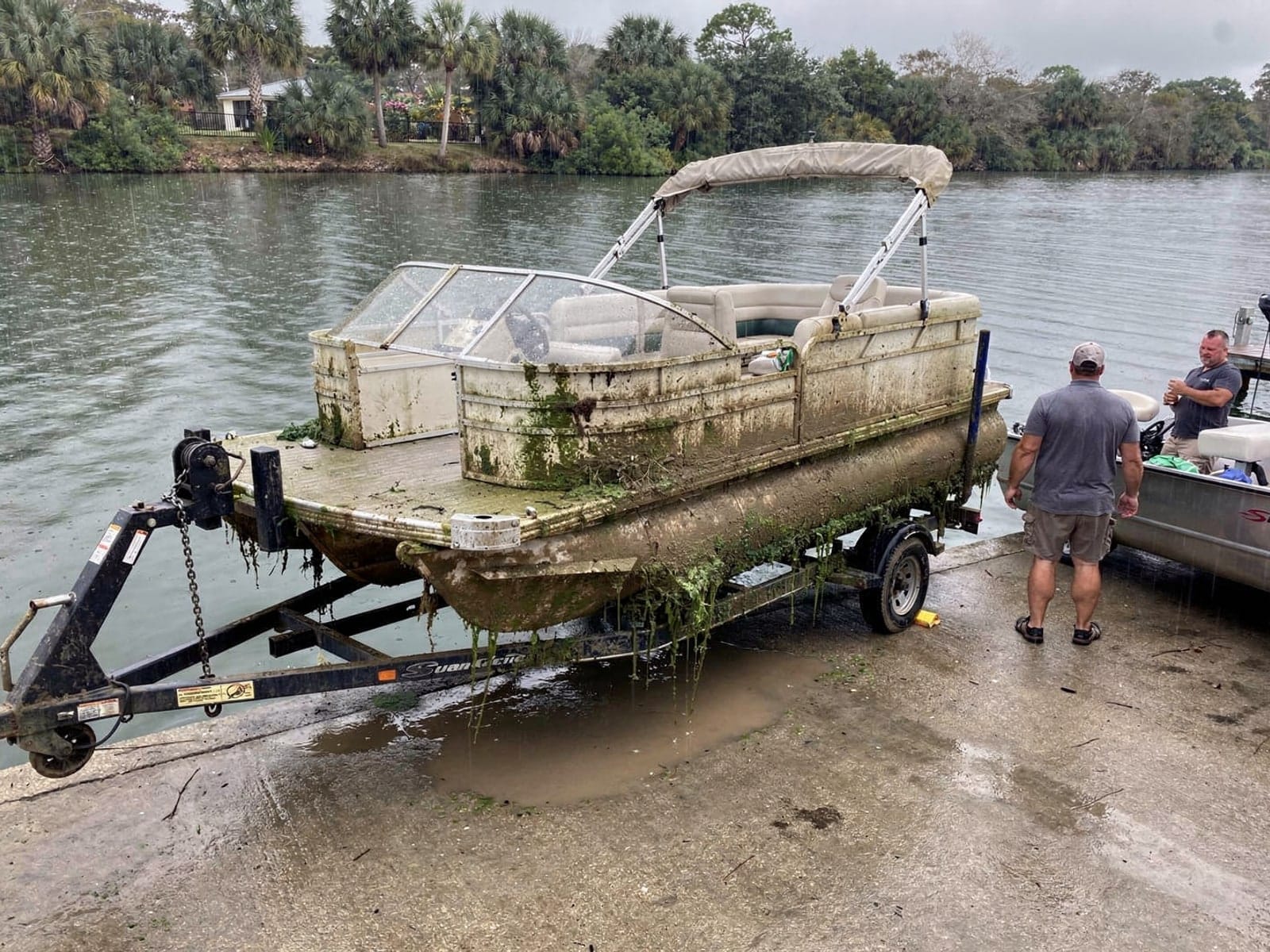Sunken boat recovery in Lealman, FL: pulled out at the ramp 22 ft Sun Tracker Party Barge 22 pulled out on a trailer at a Lealman, FL boat ramp