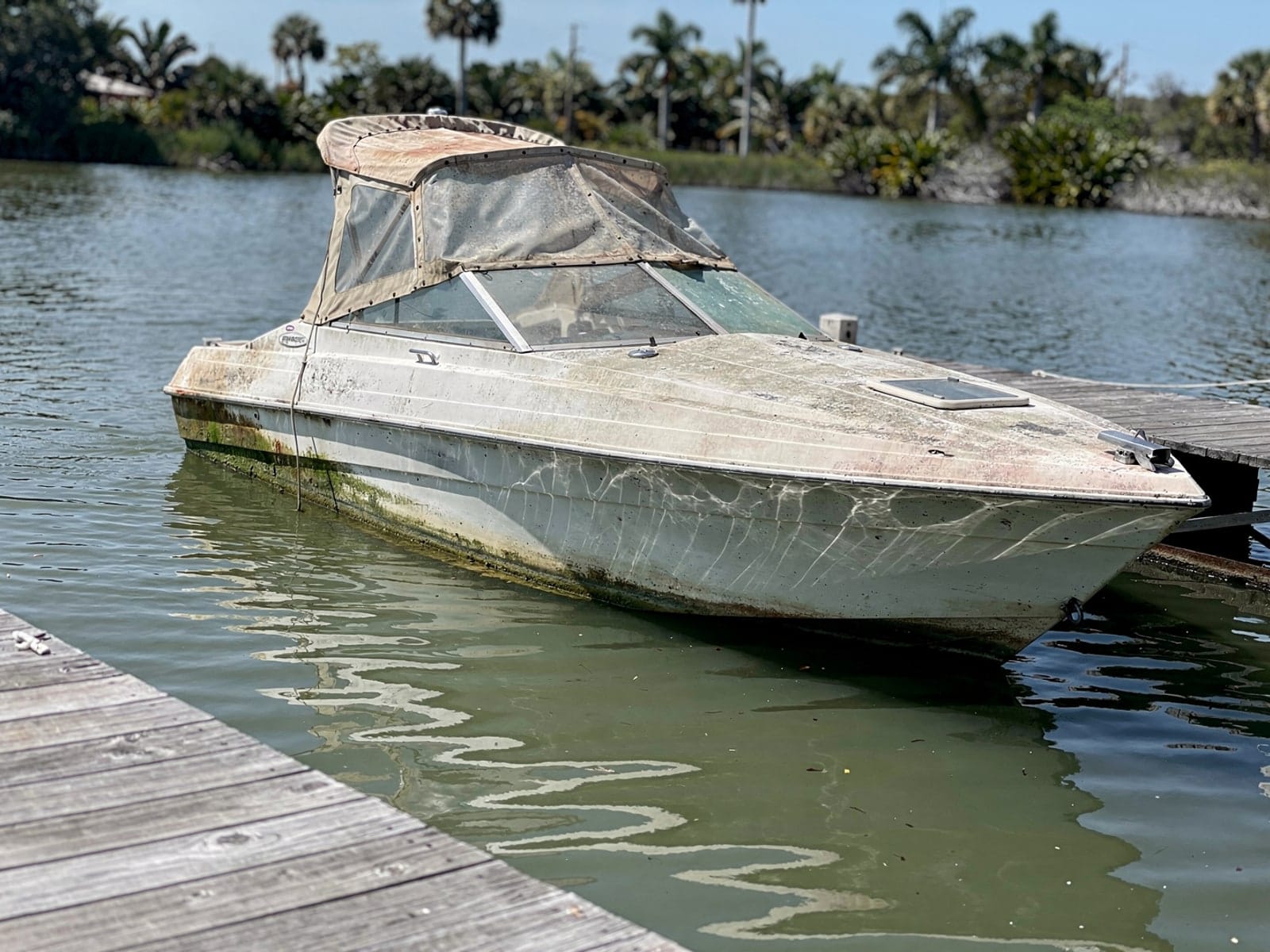 Sunken boat recovery in Liberty Triangle, FL: before Sunken 23 ft Rinker 232 at a lake dock in Liberty Triangle, FL