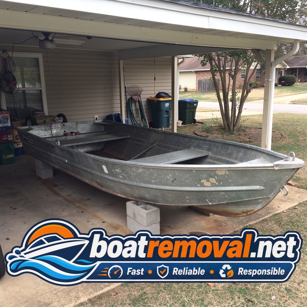 16-foot Grumman aluminum boat resting on blocks under a low carport in Little Rock, Arkansas