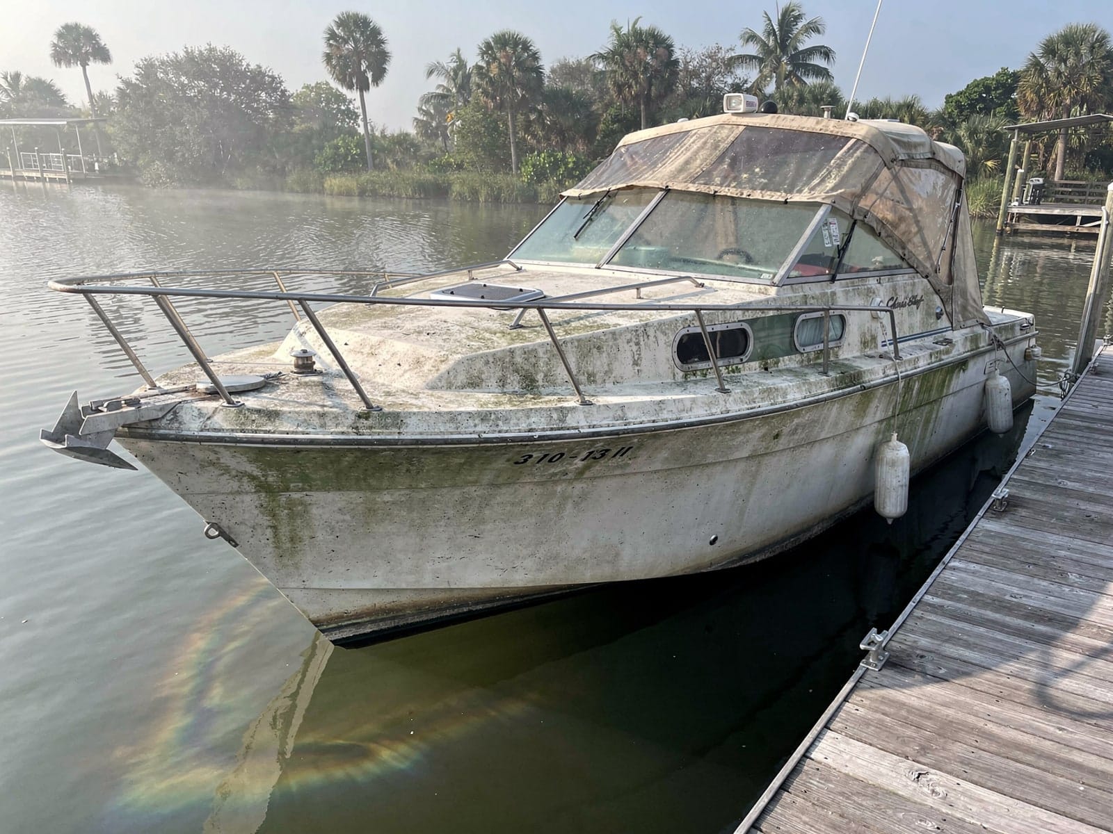 Sunken boat recovery in Margate, FL: before Sunken 23 ft Chris-Craft Cavalier at a lake dock in Margate, FL