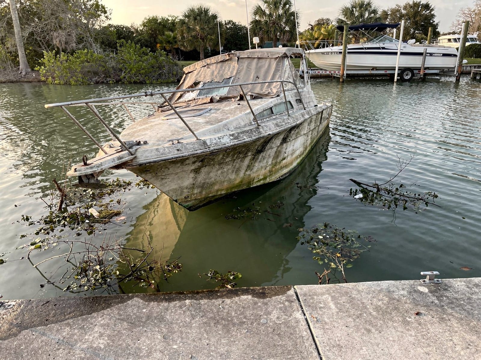 Sunken boat recovery in Gladeview, FL: before Sunken 28 ft Carver 28 by a boat ramp in Gladeview, FL